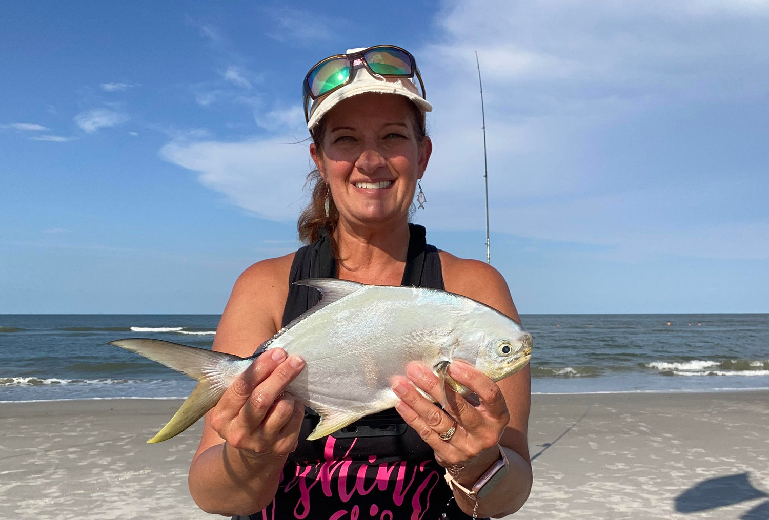 Beach fishing guide Cathy Sanders holding pompano caught on Florida beach